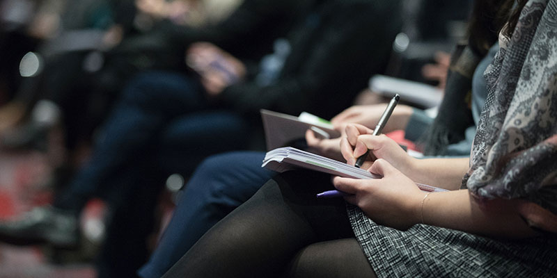 People sitting a meeting taking notes